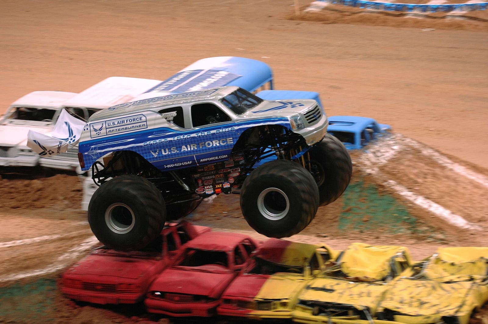 Monster truck miażdży karoserię samochodu osobowego kołem przedniej osi