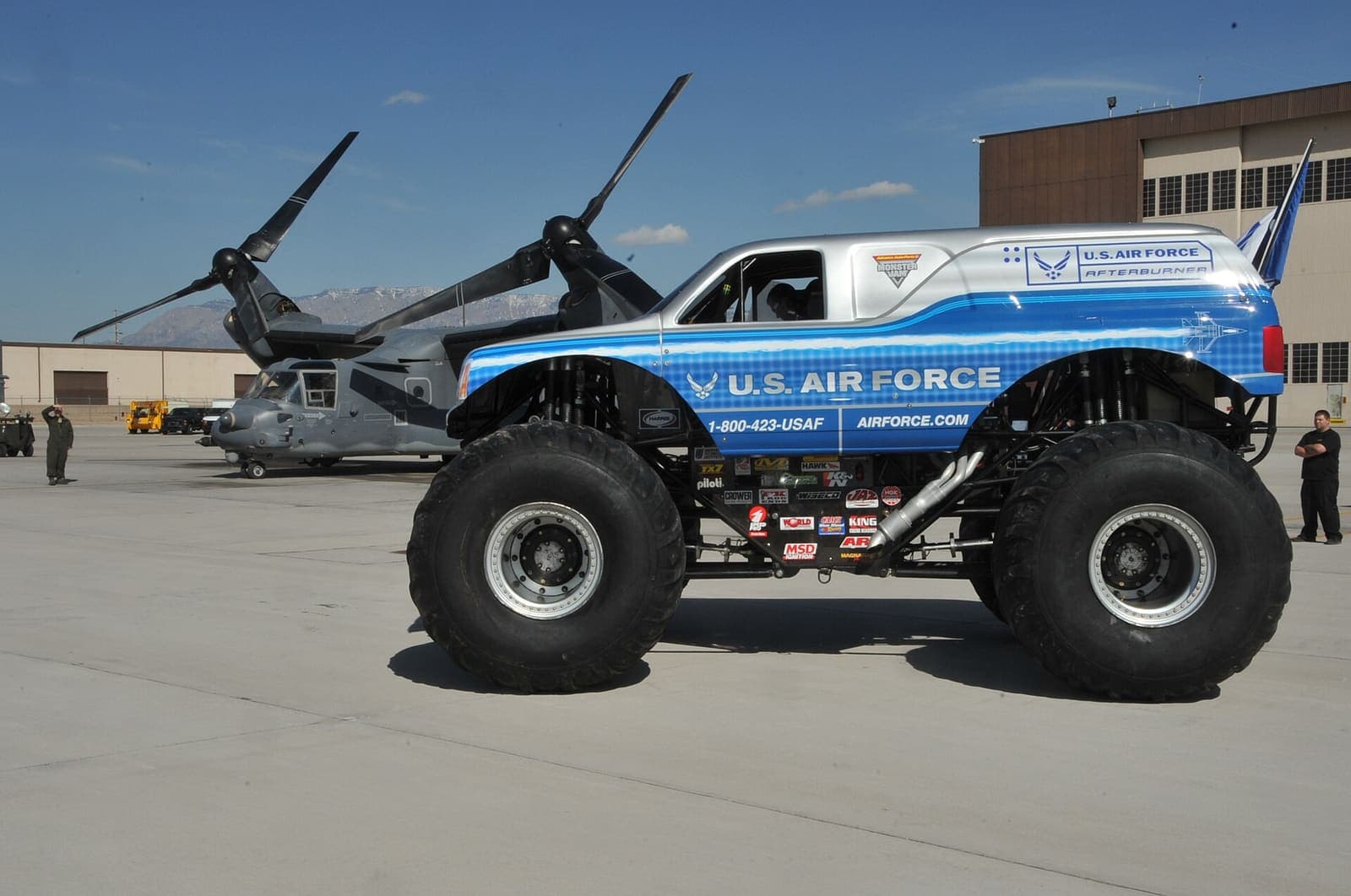 Kierowca za kierownicą monster trucka w kabinie z klatką bezpieczeństwa